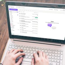 Hands on a laptop computer checking Proton Mail.